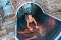 Child having fun on the slide in the children's area of Splash e Spa Tamaro