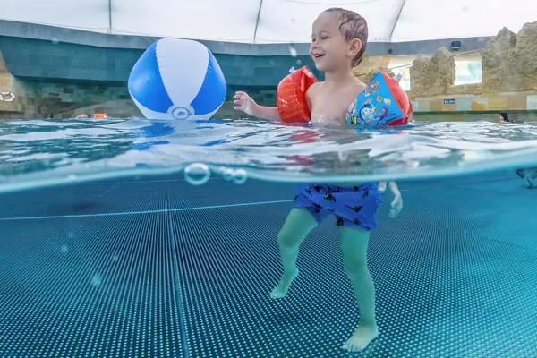 Child plays with ball in the wave pool of the Tamaro Splash and Spa